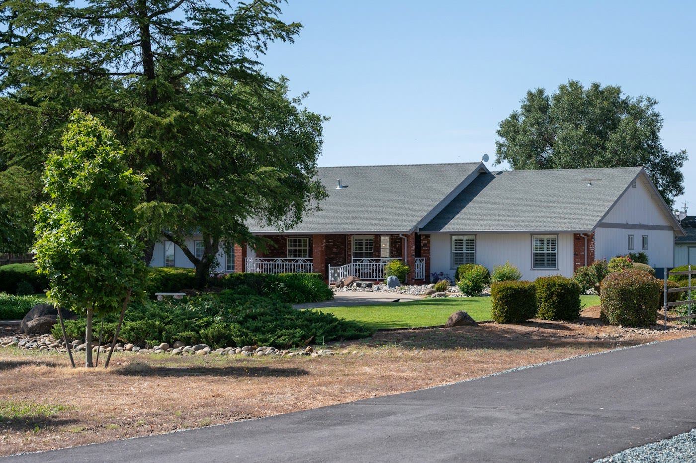 Single-story California ranch home with a green lawn and mature trees, the kind of comfortable next home many Orange County families consider when downsizing.
